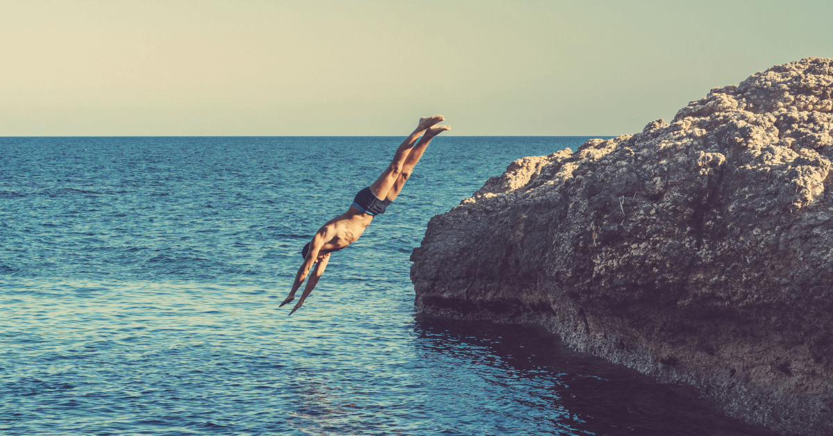 A man diving off a cliff into the ocean symbolising the rapid drop of testosterone in men over the past 50 years.