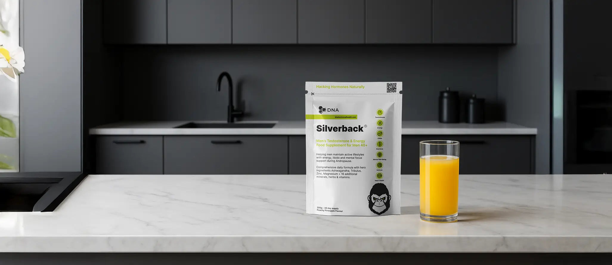 Silverback men’s testosterone and energy supplement by DNA Hormonal Health, pineapple-flavoured powder for men 40+, shown on a modern kitchen counter next to a glass of Silverback – designed to support energy, libido, and mental focus during Andropause