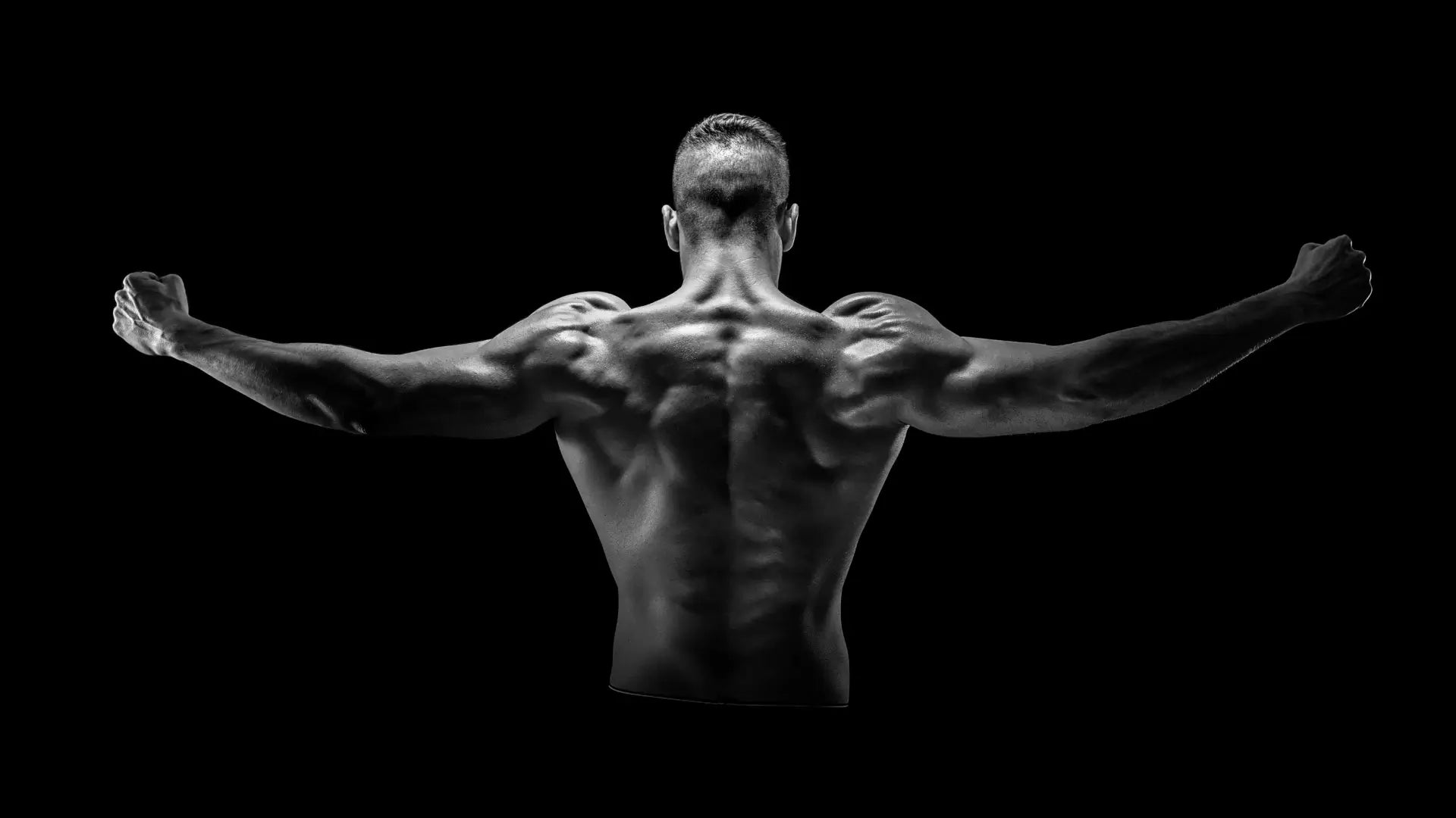 A muscular man from behind, arms outstretched, showcasing defined back and shoulders, symbolizing peak physical performance. This image promotes DNA White Wolf Testosterone Supplement with Performance support, highlighting its benefits for boosting testosterone levels naturally, improving energy, and combating symptoms of low testosterone in men aged 25-39. Perfect for those seeking effective testosterone boosters or supplements for andropause.